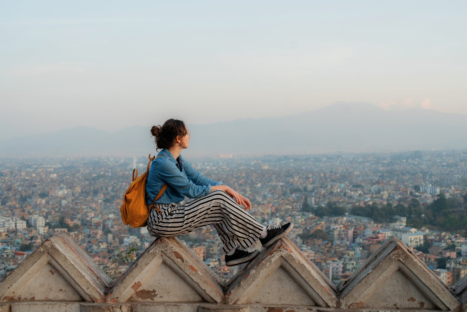 Woman sitting in Monkey temple overlooking Kathmandu cityscape