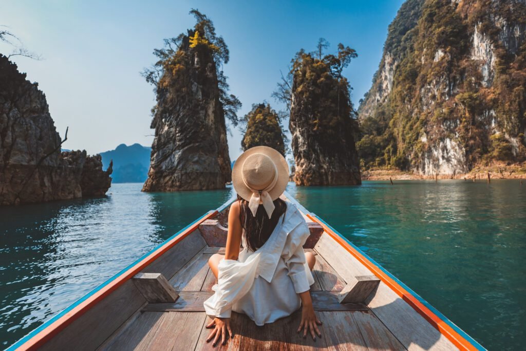 Traveler asian woman relax and travel on Thai longtail boat in Ratchaprapha Dam at Khao Sok National Park Surat Thani Thailand