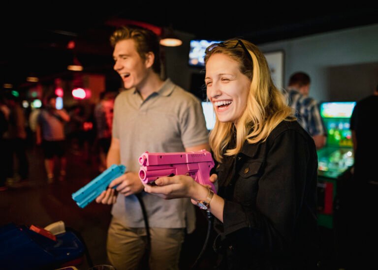 Young couple playing arcade games at a bar